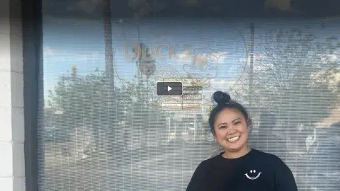 woman stands in front of restaurant window