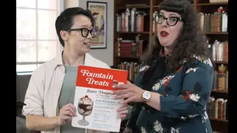 two people hold up menu titled "fountain treats"