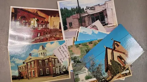 A scattered collection of old postcards featuring tourist attractions