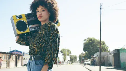 African American woman holding boombox on shoulder