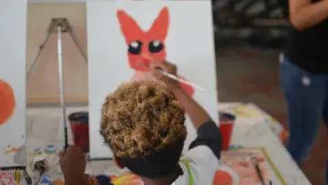 child painting on a canvas.