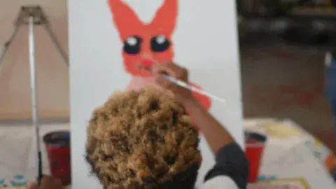 Child painting on a canvas. 