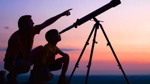 people looking into a telescope