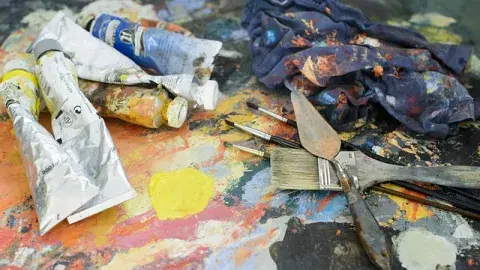 A color phot of used paint tubes and paint brushes, Image by Bilge Can Gürer from Pixabay