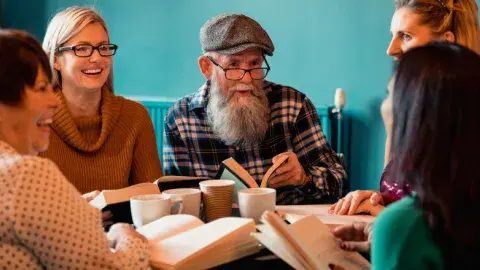 A group of adults sitting around a table with books