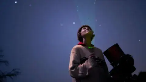 Astronomer Casey Cooper looks up at the night sky.