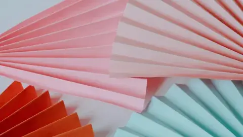 pink aqua and red folded fans on a light blue background