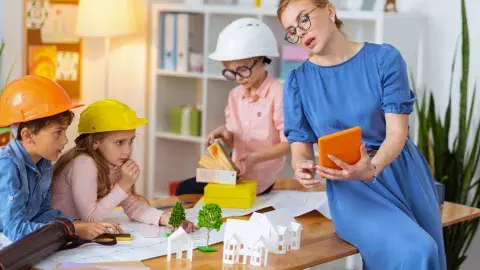 A woman and three children engage in an architecture-theme activity.