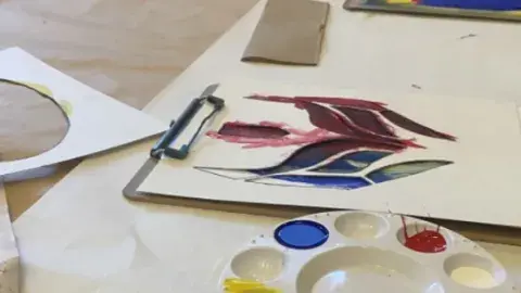 stencils and paint for creating a lucha libre mask on a table