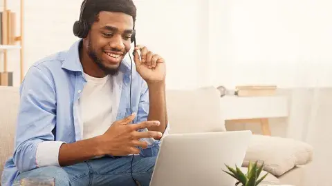 man wearing a headset while sitting in front of a laptop