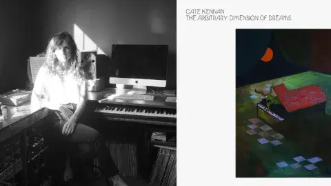 Keyboardist and synthesis Cate Kennan is pictured in front of her home studio. Next to her is the cover of her album, a painting of a piano with a being emerging under a moon. 