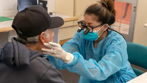 health care professional conducting an oral health exam