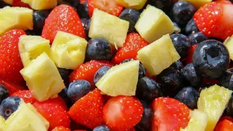 A color photograph of strawberries, pineapple and blueberries, Image by Pat from Pixabay