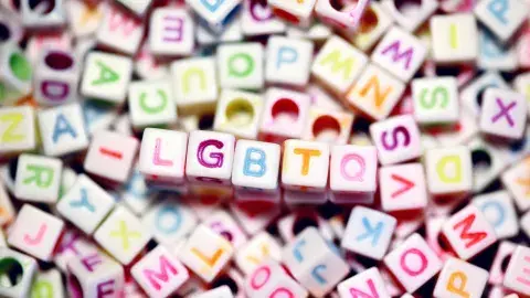 a pile of colorful letter beads with the initialism LGBTQ in the middle