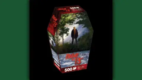 Cover of a puzzle box, man with mask standing by lake
