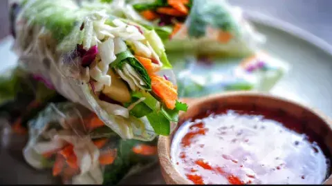 Spring rolls with a container of sauce