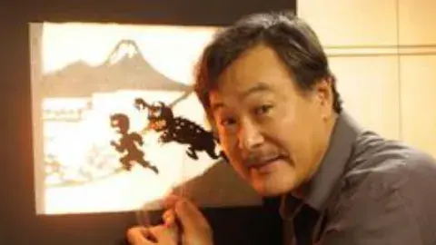An artist shows off his shadow puppet creations