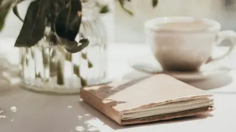 Soft journal beside coffee and flowers