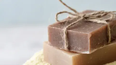 Two brown blocks of soap on a cream towel
