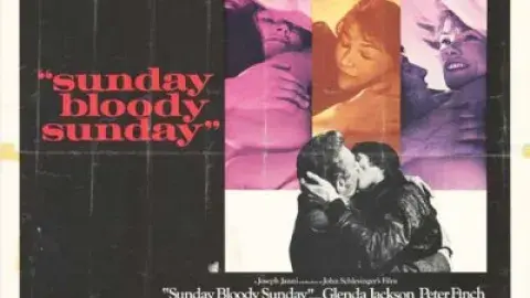 Close-up moments between characters in bed. A large black-and-white photograph shows two men passionately kissing while embracing, with one wearing a dark leather jacket.
