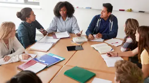 Six teenagers sitting in a semi circle. 