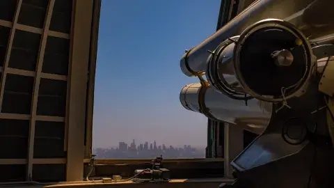 telescope at griffith observatory pointing out at the city of Los Angeles skyline