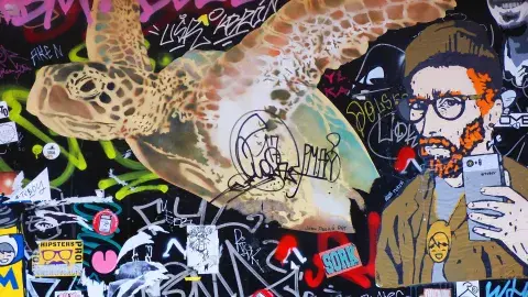 a collage of a sea turtle and Vincent Van Gogh wearing glasses and holding a phone with graffiti