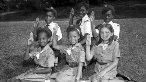 Local Girl Scout Juniors and Cadettes demonstrate the Girl Scout Sign, circa 1964.