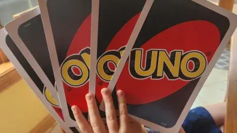 boy holding giant uno cards