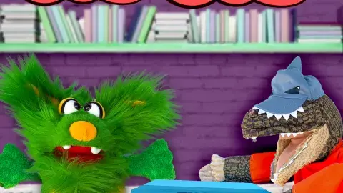 Two puppets, Ellie and Bandit with a stack of book in between them.