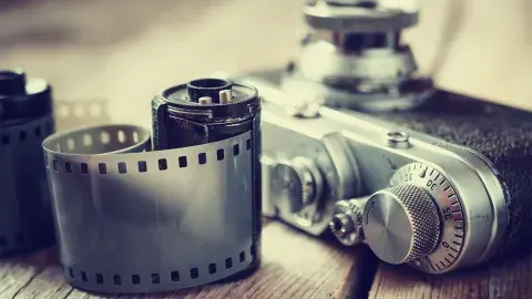 A roll of fikm near a camera