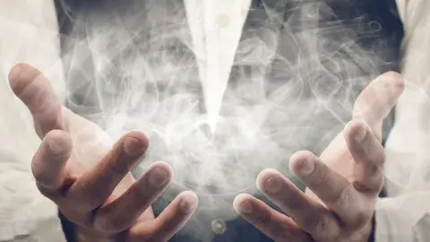 A person's hand holding a cloud of white smoke.