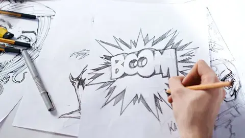 Person holding a pencil and drawing a comic bubble with the word boom in the middle.
