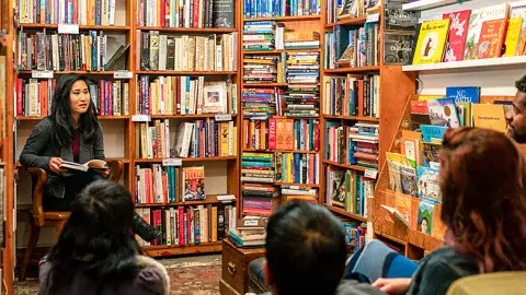 Adults sitting in a circle surrounded by books and book shelves