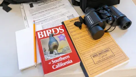 contents of birdwatching kit, including backpacks, books, binoculars 
