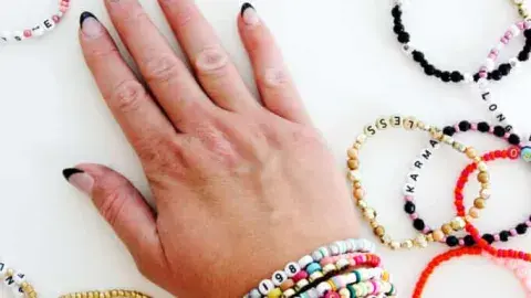 A wrist full of beaded friendship bracelets.