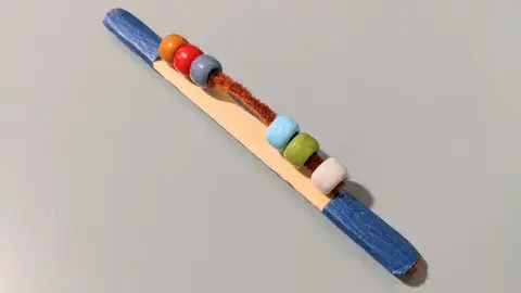 fidget stick made out craft stick, chenille stick, and beads