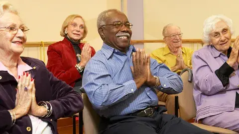 Adult sitting and doing chair yoga