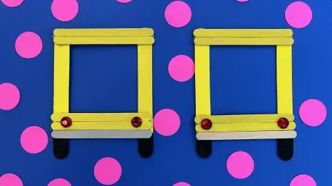 Handmade popsicle stick picture frame colored in yellow, gray, and blac