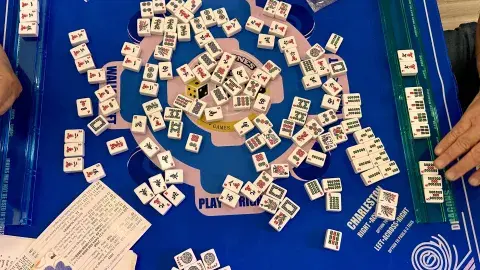 Mahjong tiles on a game board table.