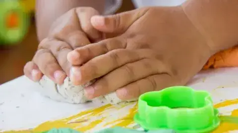 kids hands playing with playdough