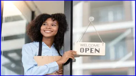 Women holding an open sign for her business