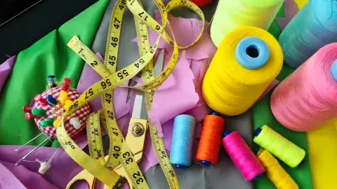 measuring tape, thread various colors, scissors, pins, pin cushion and fabric