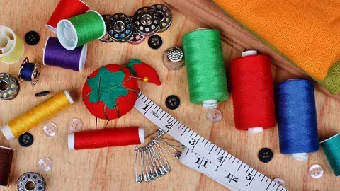 sewing material thread various colors measuring tape buttons bobbin and safety pins