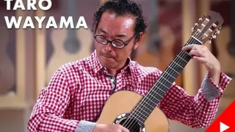 man in glasses playing a guitar 