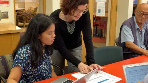 A teacher helping a student with an assignment. 