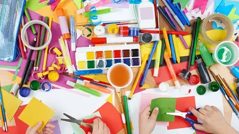 paper and pencils and glue and paint all in many colors on a table