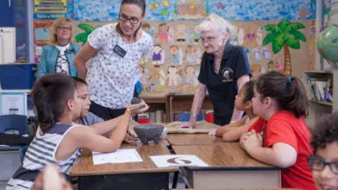 Educators interact with students in a classroom
