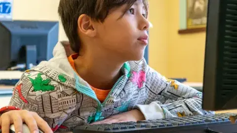 A boy using a computer.