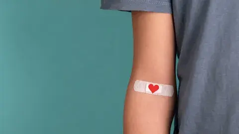 Image of an arm with a heart-themed band-aid affixed 